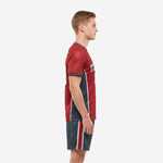 Custom red and black soccer uniform left side view displaying charcoal contrast panels on jersey and red side stripe on shorts