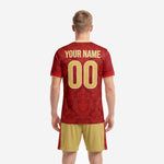 Close-up detail of custom crimson soccer jersey with full-dye sublimation baroque floral pattern and gold V-neck trim