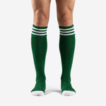Custom dark green soccer socks with white triple-stripe cuff band, front view on adult male model