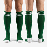 Full length view of custom dark green soccer socks over the calf with white stripe cuff and toe