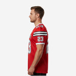 Red and black football jersey side view showing three-stripe shoulder panel, sleeve number placement, and white V-neck collar on adult male model
