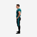 Reverse side view of teal and black American football uniform showing jersey hem length and pant stripe alignment from hip to below the knee