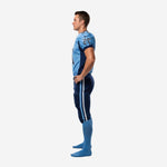 Side view of custom youth football uniform showing navy shoulder panel meeting light blue body, full-length navy pant with double light blue and white outer leg stripe