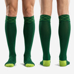 Full-length profile of custom forest green soccer socks with lime green cuff stitching and contrast footbed panels