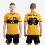 Front and back view of custom gold and black soccer uniform set with team name and number
