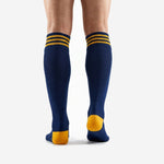 Close-up of ribbed cuff detail on custom gold soccer socks showing three Athletic Gold stripe bands on Navy Blue background