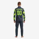 Close detail of custom graphite soccer tracksuit jacket showing neon green dot-burst splash print on sleeve and left chest logo zone