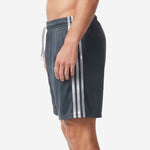 Custom gray soccer shorts with white contrast side panel stripes and elastic drawcord waistband, right side view on male model