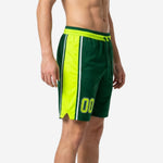Side view of custom green basketball shorts showing full-length neon yellow side panel with white inner stripe and elastic drawcord waistband