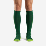 Custom green soccer socks Forest Green over the calf length with Neon Yellow side stripe on adult male player
