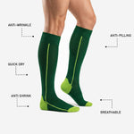 Custom green soccer socks with anti-wrinkle, quick dry, anti-pilling, and breathable performance features labeled on Forest Green sock