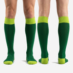 Full-length view of custom green soccer socks in Forest Green and Lime Green for soccer players