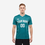 Custom green soccer team jersey in Teal with white V-neck trim and front team name and number print, worn by adult male model