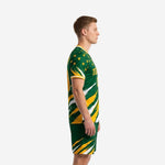 Custom green soccer uniform side view showing Athletic Gold and White slash-burst graphic on jersey and shorts