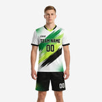 Custom green soccer uniforms front view showing neon green and white brush-stroke jersey with matching black shorts