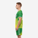 Custom green soccer uniforms Kelly Green gradient side view showing back number and shorts detail on male model