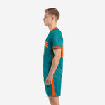 Custom green soccer uniform set with orange side stripe shorts, side view on adult male model