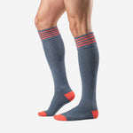Knee high grey soccer socks with coral stripe cuff band and contrast toe cap, angled calf view