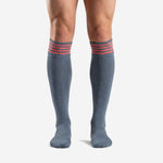Custom grey soccer socks with 4 coral hooped cuff stripes, front view on adult male model