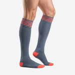 Custom grey soccer socks showing coral heel and toe panels with striped cuff, side angle view