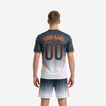 Custom grey soccer jersey detail showing Charcoal gradient body, V-neckline, and Orange stripe trim for team customization