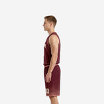 Left side view of maroon sublimated basketball uniform set showing armhole binding and shorts hem fade detail