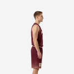 Side view of maroon custom high school basketball uniform showing V-neck jersey and matching shorts with blush waistband