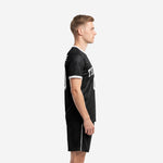 Side view of custom all black soccer uniform showing white sleeve cuff trim and matching black shorts with white side stripe