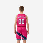 Left side view of custom kids basketball uniform set in hot pink and navy showing diagonal stripe panel on jersey and shorts
