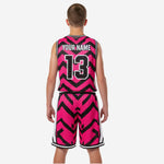Second side view of custom kids basketball uniforms in hot pink and black chevron print showing athletic cut jersey silhouette and shorts leg with player number