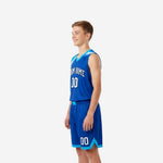 Left side view of royal blue and cyan youth basketball jersey and shorts showing cyan armhole binding and shorts chevron hem detail