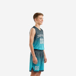 Youth boy wearing custom kids basketball uniforms with arched team name and number 00 on teal gradient V-neck jersey and matching shorts