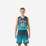 Custom kids basketball uniforms in teal-to-charcoal gradient showing full two-piece jersey and shorts set, front and back views