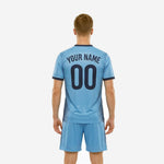 Custom light blue soccer jersey detail showing radiating navy stripe graphic and V-neck collar trim on performance polyester fabric
