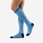Custom light blue soccer socks showing over-the-calf length and navy stripe cuff, angled side view