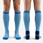 Full-length view of custom light blue and navy soccer socks showing sock height above shin guard position