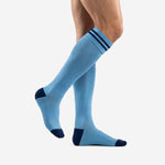Custom light blue soccer socks with navy heel and toe panels, side profile view on adult male model