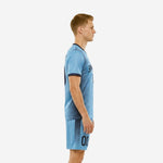 Custom light blue soccer uniform left side view displaying navy stripe side panels on jersey and shorts on adult male model
