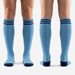 Full-length pair of custom light blue soccer socks with navy stripes, over-the-calf length for squad orders