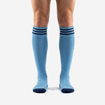 Custom light blue soccer socks with three navy blue cuff stripes and navy toe, front view on adult male model