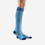 Custom light blue soccer socks with navy stripe cuff and reinforced navy heel, side profile view on adult male model