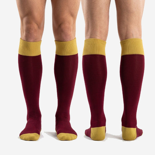 Full-length view of custom maroon soccer socks with Athletic Gold contrast zones on male model