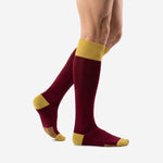 Custom maroon soccer socks with Athletic Gold heel and toe panels, side profile view on male model