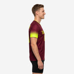 Custom maroon soccer training jersey showing neon yellow dot-burst gradient sleeve transition, left side view on adult male model