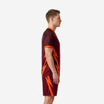 Custom orange soccer uniform side view left showing full-dye sublimation lightning graphic on maroon jersey and shorts
