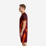 Custom maroon orange soccer uniform side view right displaying bolt design on shorts leg and orange sleeve trim