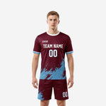 Custom maroon soccer uniforms with sky blue splash print, front view of full 2-piece kit on male model