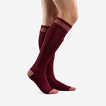 Maroon knee-high soccer socks with tonal contrast cuff stripe, left side profile on adult male