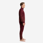Custom maroon soccer tracksuit side view showing dot-burst sublimation pattern across jacket and tapered pants on adult male model