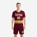Custom maroon soccer uniforms front view showing Athletic Gold horizontal band and cream V-neck trim on men's jersey and shorts set